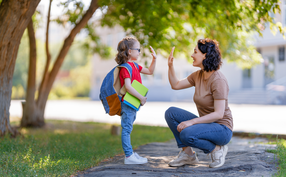 Mother giving daughter high five before taking her to school ©Yuganov Konstantin