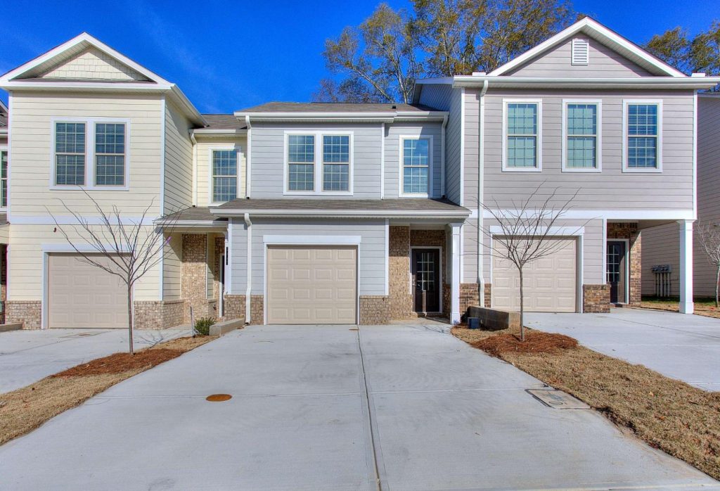 New Peachtree Building Group townhomes in Atlanta with garages and driveways.