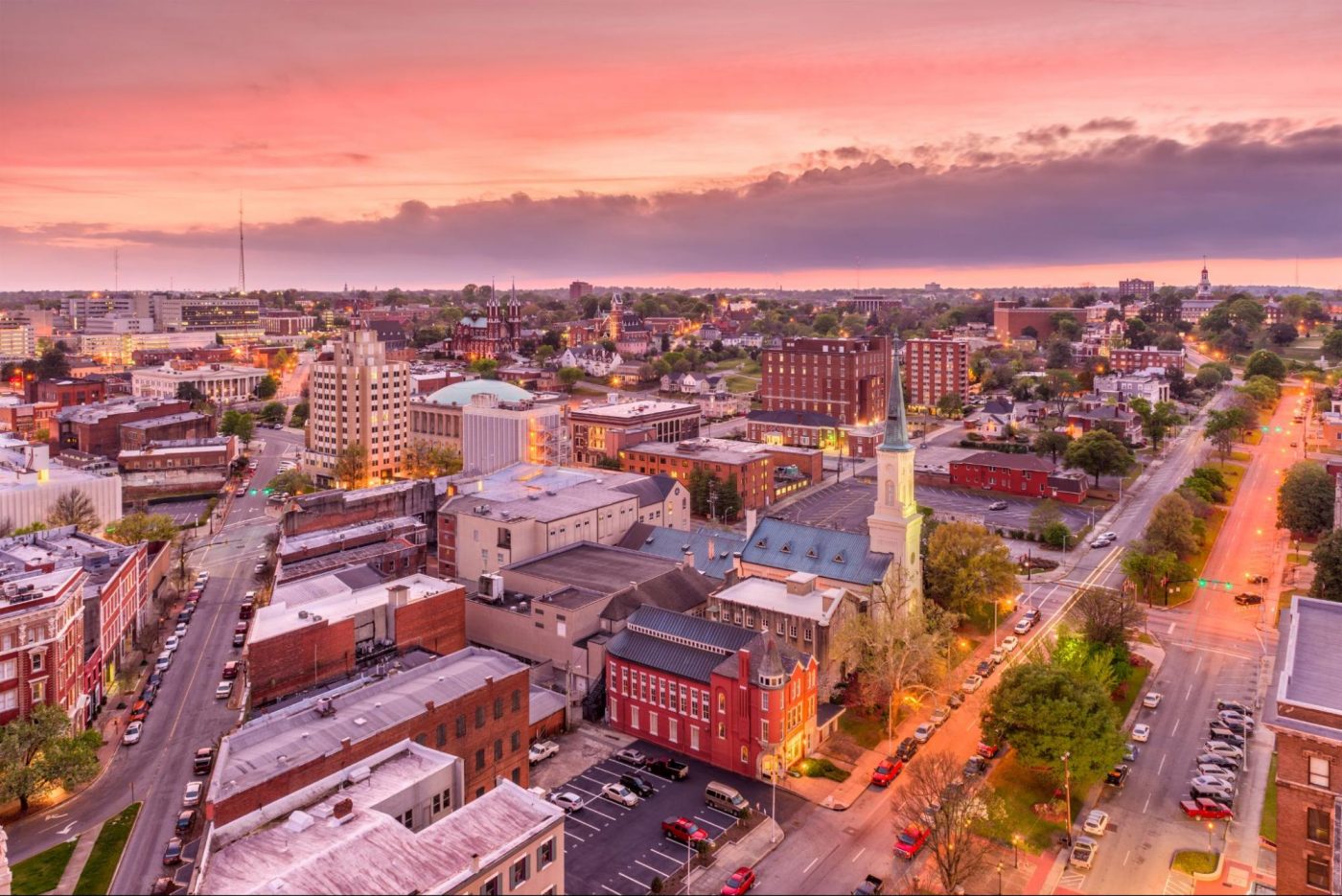 Aerial view of Downtown Macon, GA, at sunset with historic buildings and city streets ©Sean Pavone