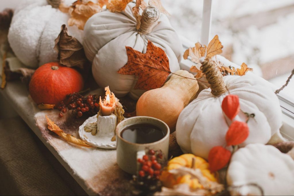 Thanksgiving table centerpiece with pumpkins, candles, and fall decor.
©Bogdan Sonjachnyj