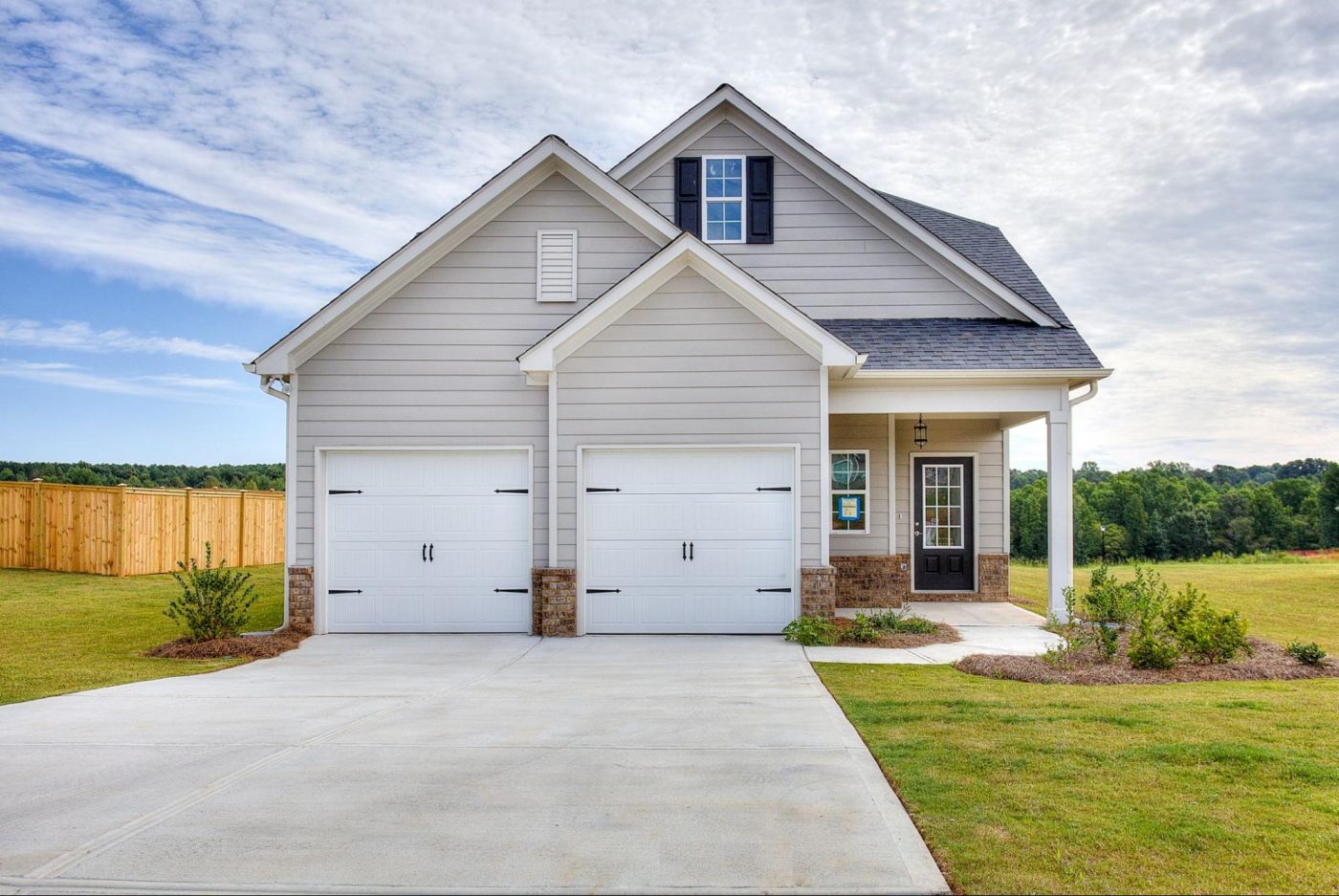 New construction single-family home with a two-car garage and landscaped front yard in Georgia.