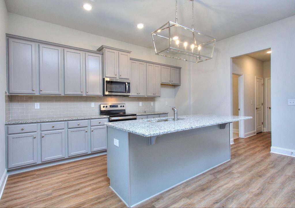 Modern kitchen with grey cabinets and a granite island in a Bowers Estates home.