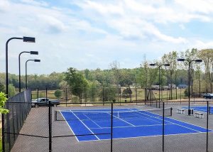 Fenced outdoor blue tennis and pickleball courts in Homer, Georgia