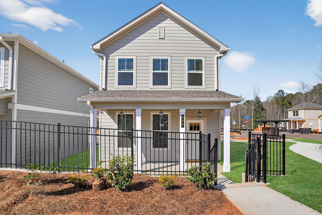 two-story cottage in a community, has yard space and is fenced in.
