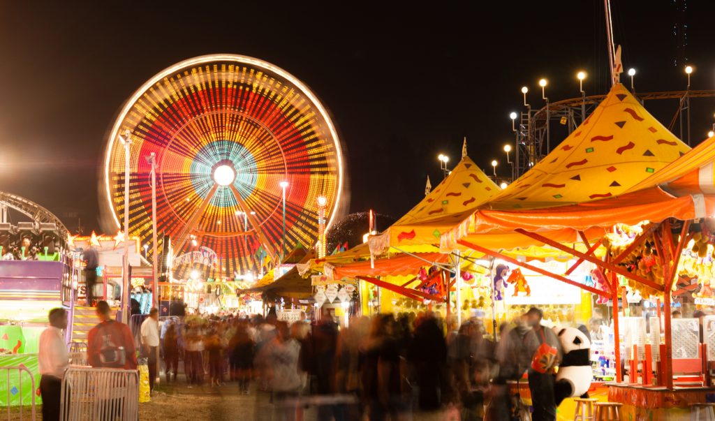 state fair featuring a Ferris wheel and carousel at night
©Real Window Creative